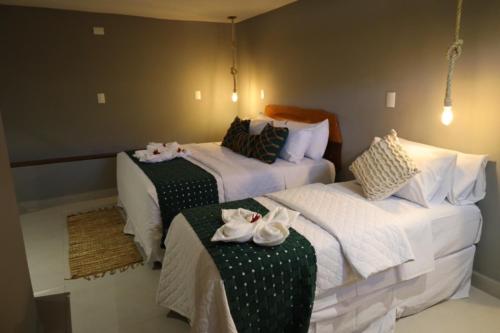 Dos camas en una habitación de hotel con toallas. en Villa Xodó en Fernando de Noronha