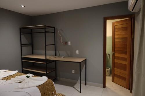a bedroom with a bed and a desk and a closet at Villa Xodó in Fernando de Noronha