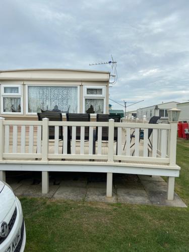 a white bench in front of a house at i13 the chase caravan park in Ingoldmells