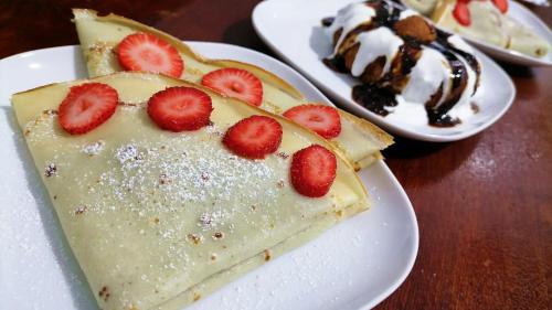 a piece of cake on a plate with strawberries on it at Hanul Vanatorului in Gureni