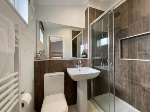 uma casa de banho com um WC, um lavatório e um chuveiro em Alde Lodge - 5 mins from beach with EV Point em Aldeburgh