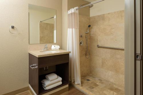 uma casa de banho com um lavatório e um chuveiro em Extended Suites Chihuahua La Juventud em Chihuahua