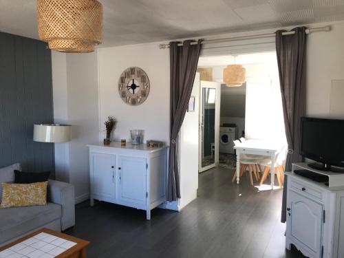 een woonkamer met een bank en een tv bij Ambleteuse appartement vue mer in Ambleteuse