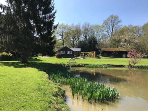 a small pond with a house in the background at Halfmoon Lodge @ Knights Hole wheelchair access in Cranbrook