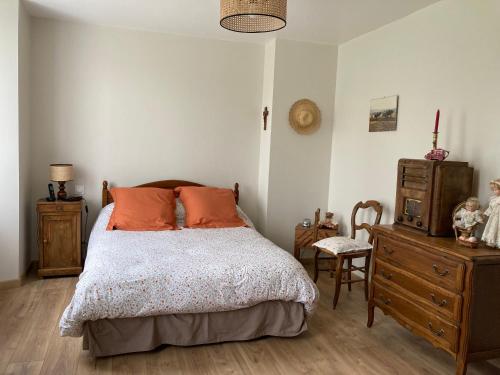 ein Schlafzimmer mit einem Bett und einer Holzkommode in der Unterkunft la Louvière 