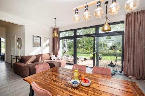 a living room with a wooden table and a couch at Revalia Vintse Villas 