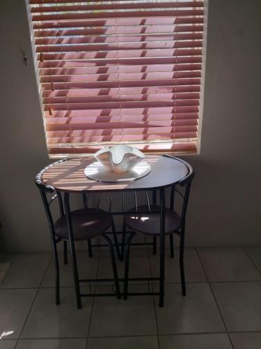 a table and two chairs with a table and a window at Prince Alfreds in Caledon