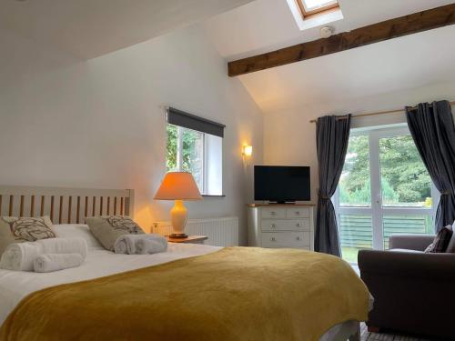 1 dormitorio con 2 camas, TV y silla en Cross Keys Inn en Penrith