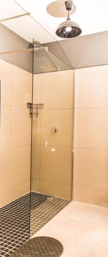 a shower with a glass door in a bathroom at Mash-G Villa Guest House in Phalaborwa