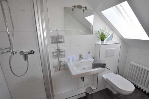 a white bathroom with a shower and a sink at Ferienwohnung T _ T 1 in Malente