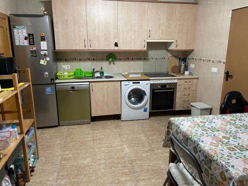 a kitchen with a washing machine and a washer at Vivienda compartida con ambiente familiar in Seseña