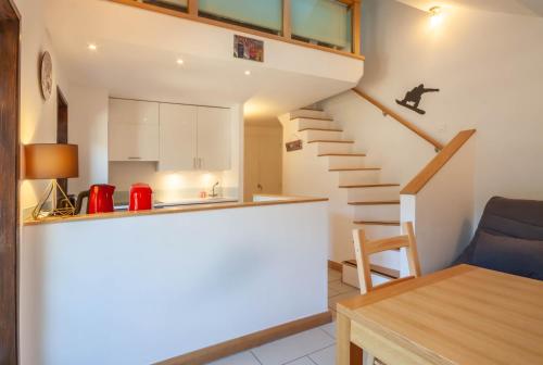 une petite cuisine et un escalier dans une petite maison dans l'établissement Cimes 20, à Morzine