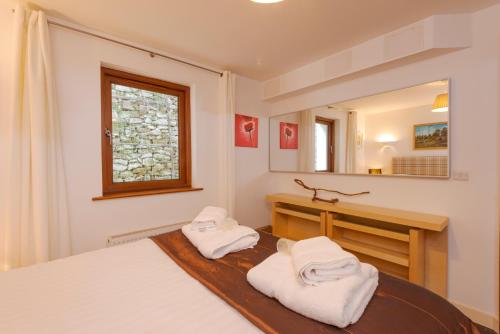 a bedroom with a bed and a vanity and a mirror at White Lodge Apartments in Mawgan Porth