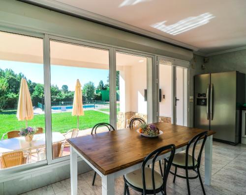 a kitchen and dining room with a table and chairs at Casa Rural El Retiro de Gredos by RetiroRural in Arenas de San Pedro