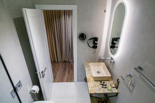a white bathroom with a sink and a shower at Vecchia Boutique Hotel in Korçë