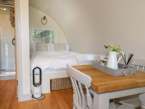 a bedroom with a bed and a wooden table at Larch in Uttoxeter