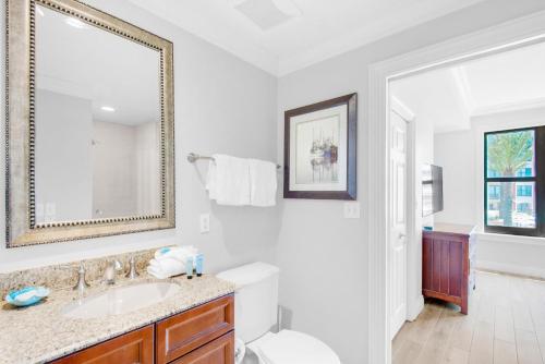 Baño blanco con lavabo y espejo en Emerald Grande W222- Rexford's BEACH Retreat en Destin