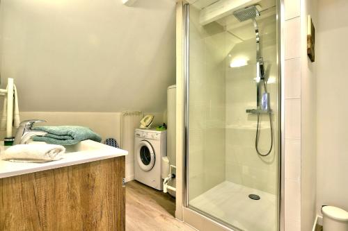 a bathroom with a shower and a washing machine at Ty Koant au coeur du Guilvinec - Wifi inclus - Draps et serviettes inclus in Le Guilvinec