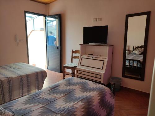 - une chambre avec un lit, une télévision et un miroir dans l'établissement Casa del pozzo, à Furci Siculo