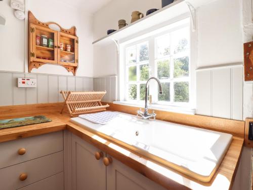 a kitchen with a sink and a window at Warren Cottage in Leavenheath