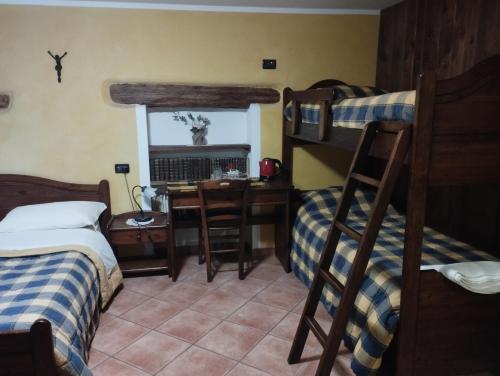 a bedroom with two bunk beds and a desk at Chambres D'Hotes Les Fleurs in Pila