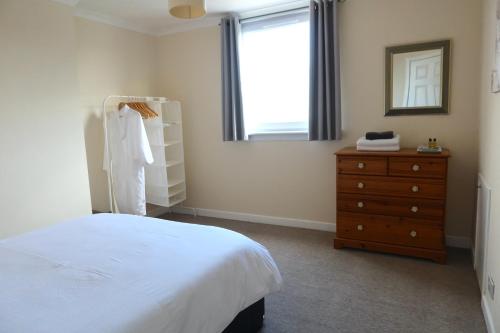 1 dormitorio con 1 cama, vestidor y ventana en Large Apartment near the Beach & World Class Golf en Methil