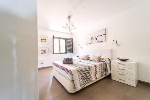 Casa Martín. في Playa del Aguila: غرفة نوم بيضاء مع سرير وخزانة