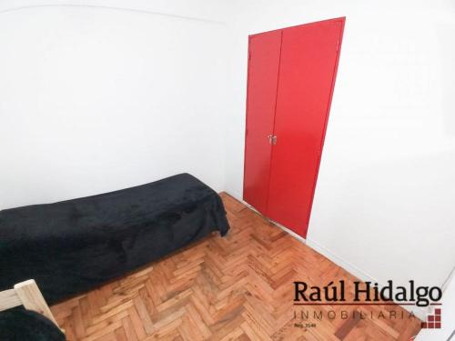 1 dormitorio con 1 cama y puerta roja en Departamento Mar del plata en Mar del Plata