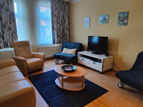 ein Wohnzimmer mit einem Sofa und einem TV in der Unterkunft Ferienwohnung Rustica in Wernigerode