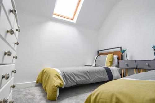 een slaapkamer met 2 bedden en een spiegel bij 51 Fernhill Heights in Bridport
