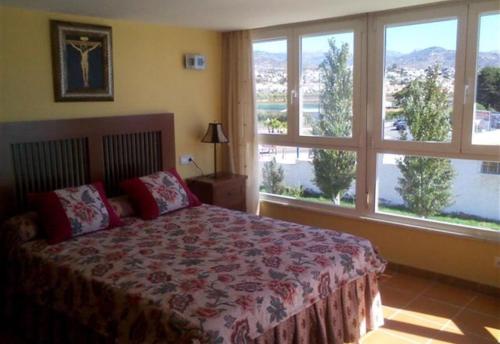 1 dormitorio con cama y ventana grande en Sea front house, en Torre del Mar