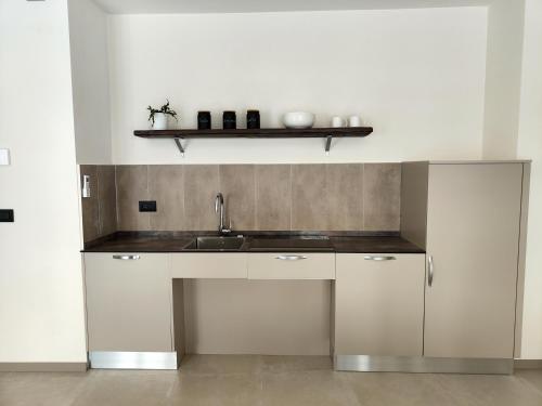 a kitchen with white cabinets and a sink at Domus Acaja in Pinerolo