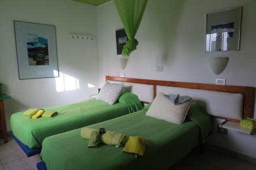 two beds in a room with green sheets at Golondrina 17 - Bungalow con giardino a Matagorda - Fronte mare - Aria condizionata - Piscina in Los Pocillos