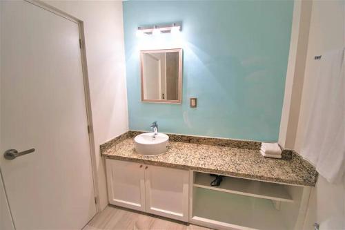 a bathroom with a sink and a mirror at Bartolome Oceanfront Suites in Isla Mujeres