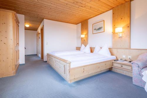 sypialnia z dużym białym łóżkiem i kanapą w obiekcie Landhotel Atzmüller w mieście Waxenberg
