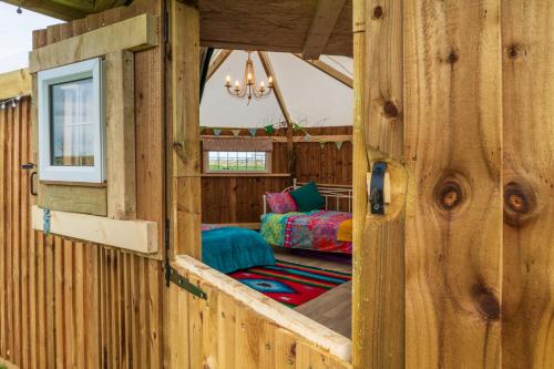 a view of a wooden room with a bedroom at Hatters Meadows Glamping in Ely