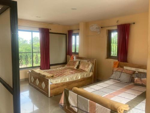 1 dormitorio con 2 camas y ventana en NeelRatna Bed And Breakfast, en Shirdi