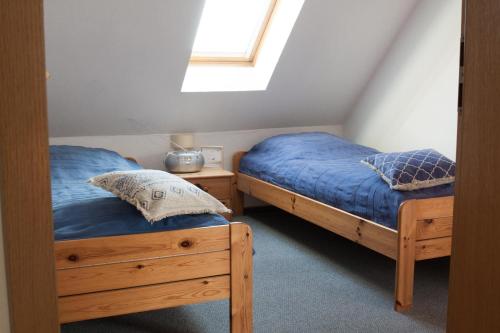 2 camas individuales en una habitación con ventana en Haus Tjalk Ferienhaus Tjalk links en Norddeich