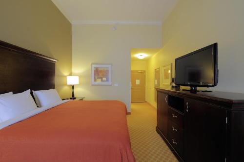 a hotel room with a bed and a flat screen tv at Country Inn & Suites by Radisson, Columbia at Harbison, SC in Columbia