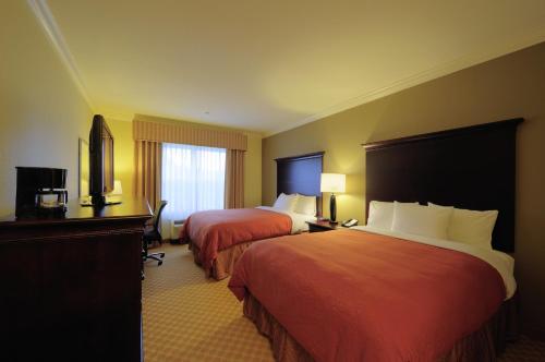 a hotel room with two beds and a television at Country Inn & Suites by Radisson, Columbia at Harbison, SC in Columbia