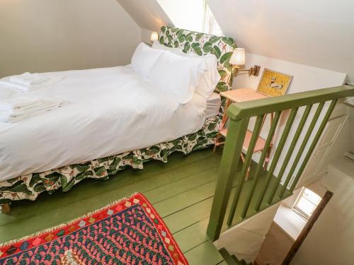 a small bedroom with a bed and a stair case at 31 Manor Road in Charlbury