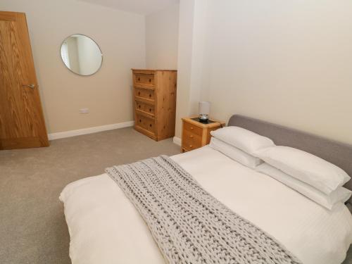 1 dormitorio con 1 cama con sábanas blancas y espejo en Chelsea House en Melton Mowbray