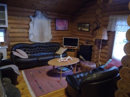 sala de estar con sofá y mesa en Helmi Äärelä en Vuotso