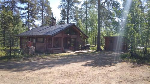 una cabaña de madera en medio de un bosque en Helmi Äärelä, en Vuotso