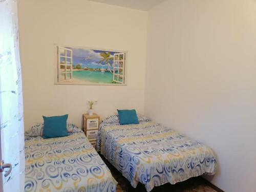 um quarto com duas camas e um quadro na parede em Chiclana El Principito em Chiclana de la Frontera