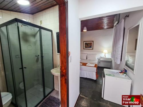 uma casa de banho com um chuveiro, um WC e um lavatório. em Hotel Vilar Formoso em Penedo