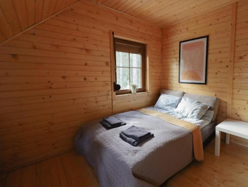 1 dormitorio con 1 cama en una cabaña de madera en Sea Zone Domek całoroczny przy plaży, en Dębki
