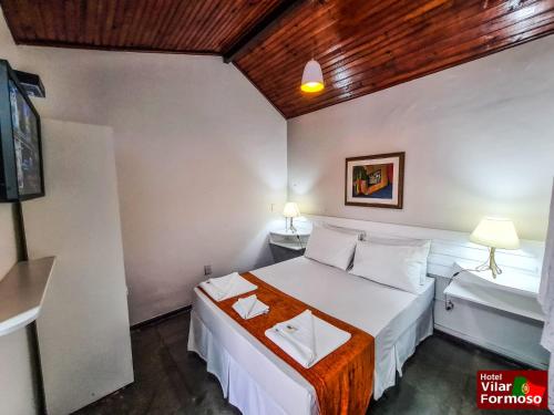 a hotel room with a bed and a tv at Hotel Vilar Formoso in Penedo