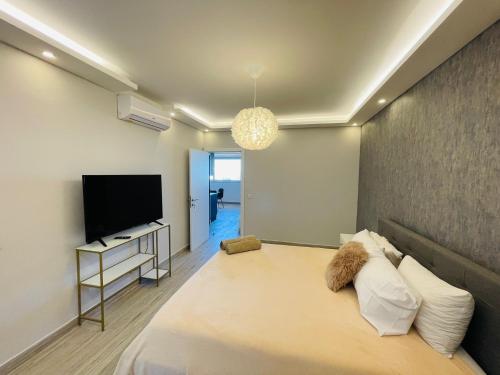 a bedroom with a large bed and a flat screen tv at Ana Seafront Haven Apartment in Il-Gżira