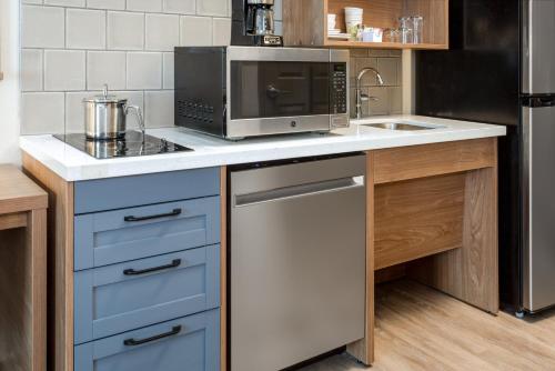 a kitchen with a microwave and a dishwasher at Candlewood Suites Grand Junction by IHG in Grand Junction